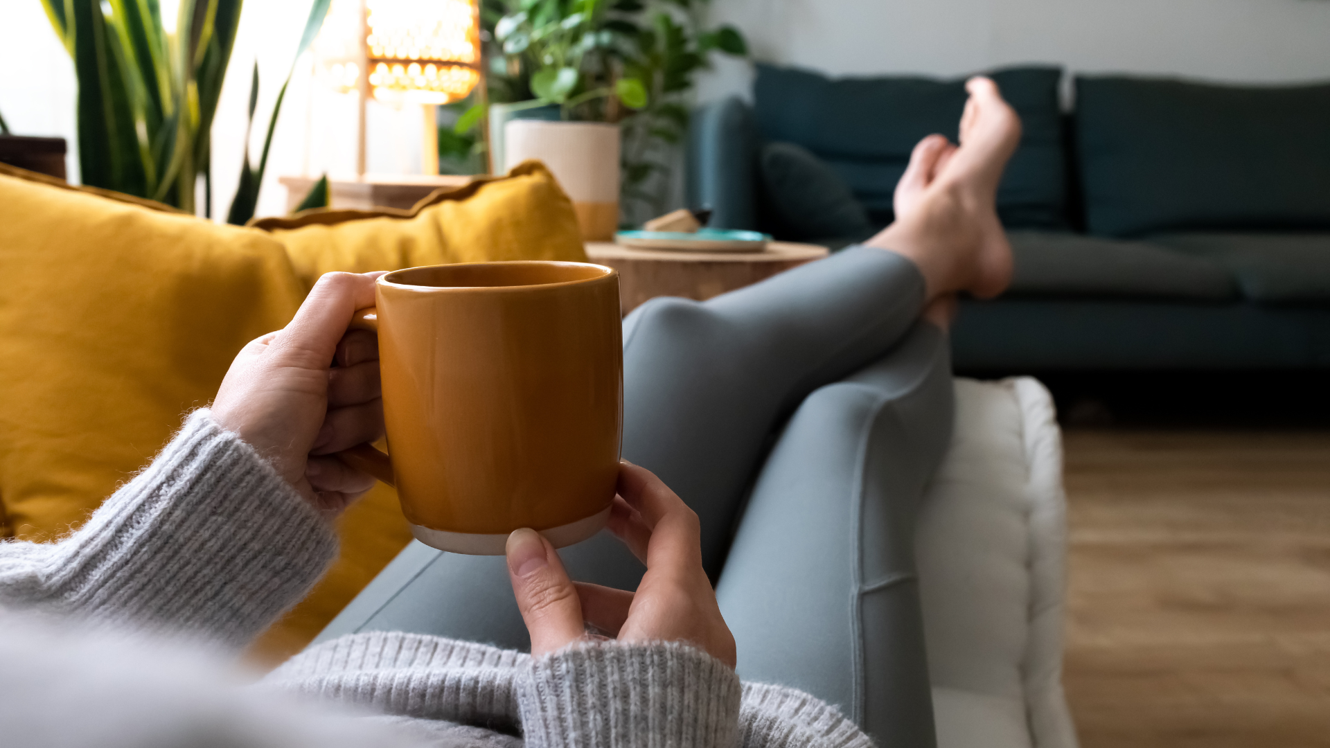 A lady on her sofa enjoying a cup of coffee